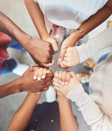 People put their hands in together to show support for each other at an alcohol rehab.