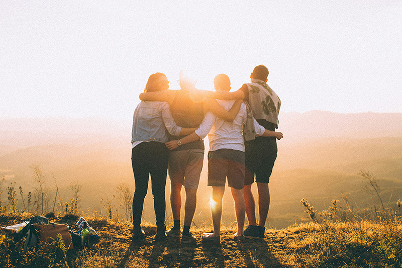 A group of friends look out at a viewpoint.