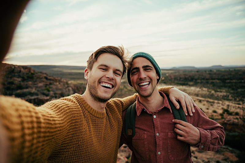 Two friends smile at the camera while hiking near Nashua, New Hampshire.