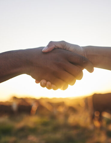 Two people shake hands.