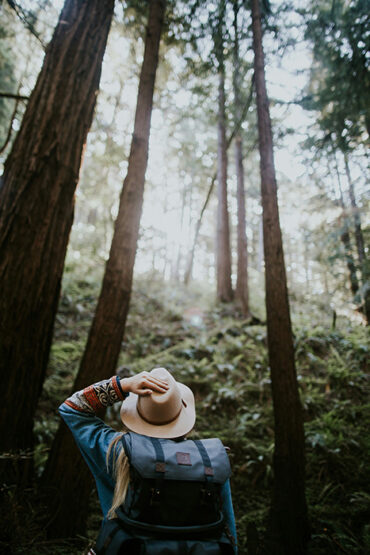 A woman goes hiking in the forest in Vermont.