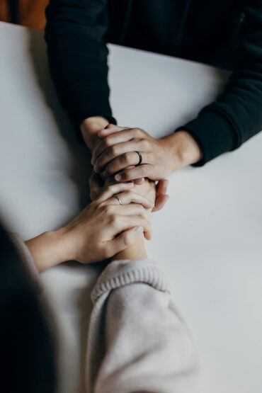 Two people support each other at a heroin treatment center.