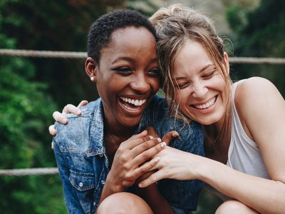 Two friends lean on each other for emotional support after finishing a fentanyl addiction treatment program.